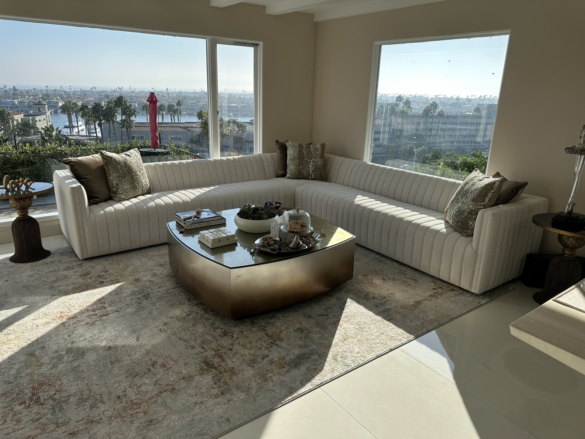 Curved cream sectional with brass table and view